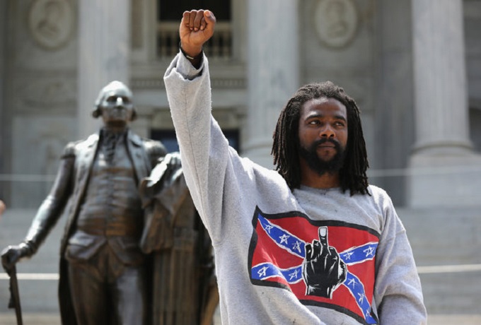 COLUMBIA, SC - JULY 18: A man holds a black power salute during a Black Educators for Justice rally at the South Carolina state house on July 18, 2015 in Columbia, South Carolina. The White Knights of the Ku Klux Klan were scheduled to hold a rally there afterwards, and police presence was heavy to prevent altercations between the two camps. (Photo by John Moore/Getty Images)